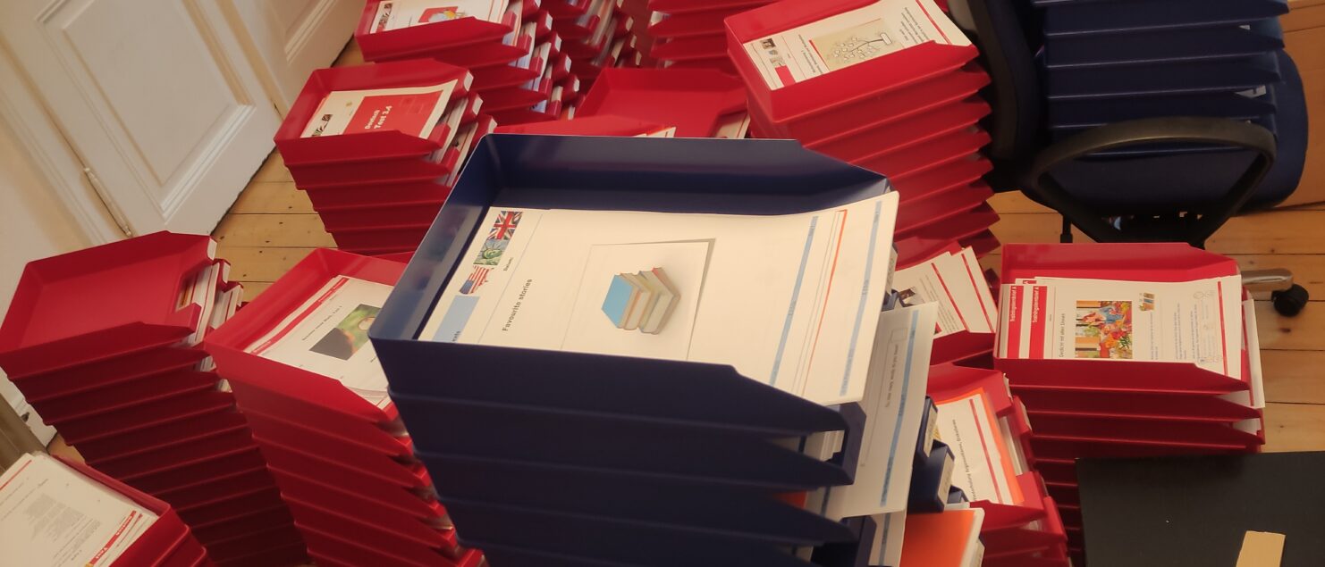 mehrere Stapel mit Ablagekörben, die mit Lernbriefen der Flex-Fernschule gefüllt sind