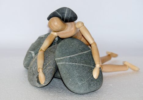 eine Holzpuppe ist unter Steinen begraben - Bild ist dekorativ